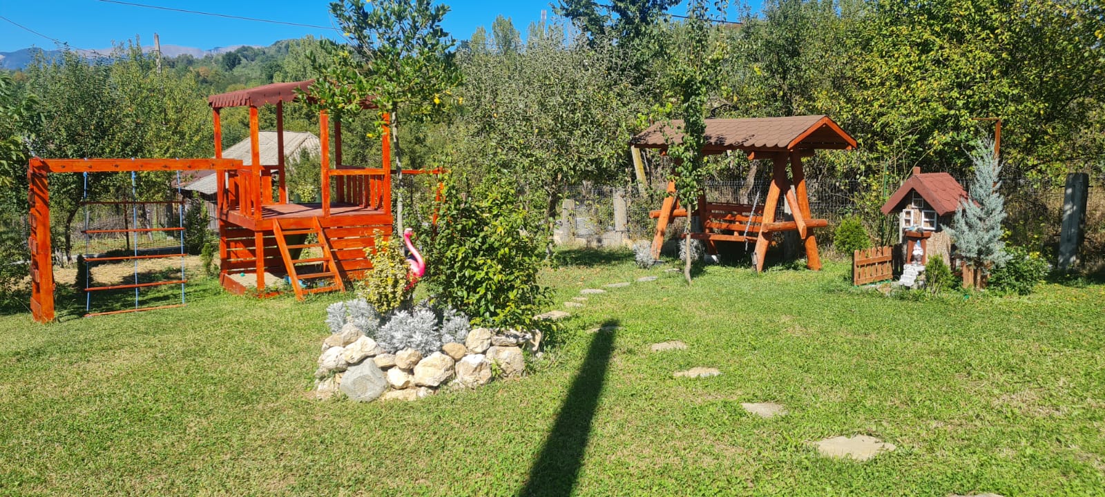 Gradina pensiune Valcea cu loc de joaca copii, trambulina si leagane din lemn