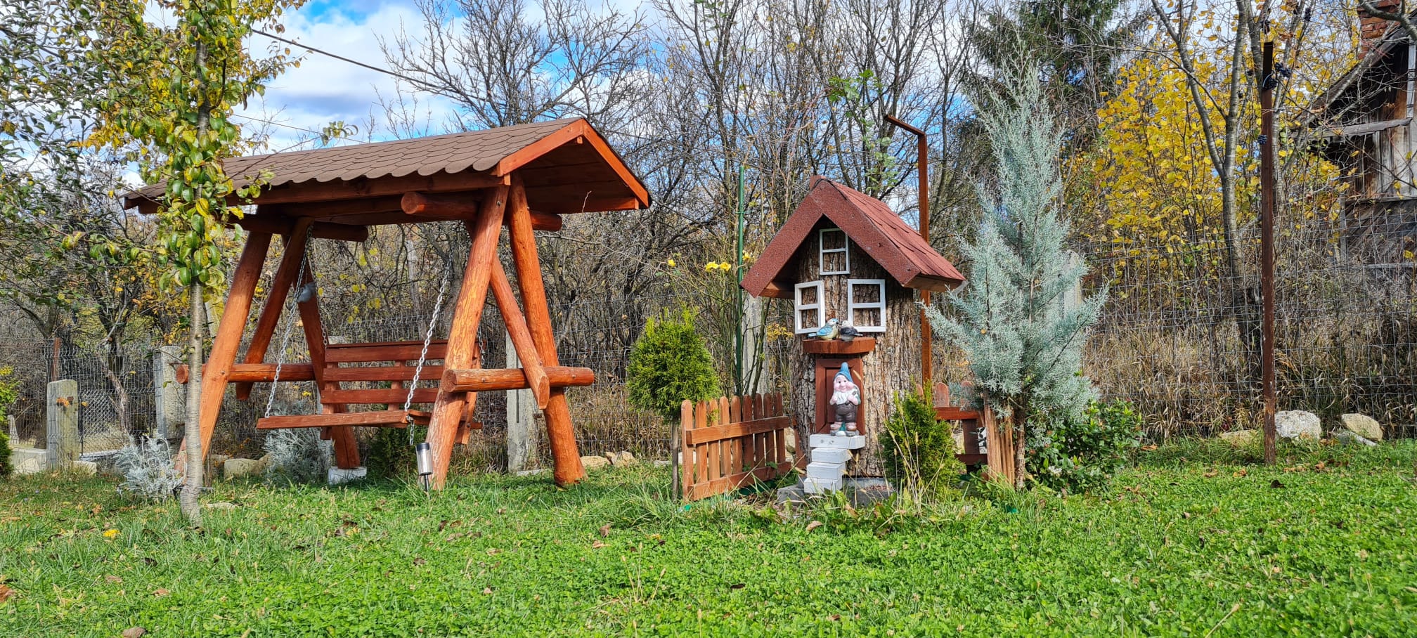 Leagan din lemn si casuta de poveste in gradina pensiunii Vila Fane