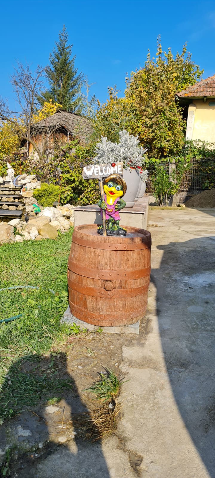 Intrare pensiune Vila Fane cu figurina Welcome pe butoi de lemn